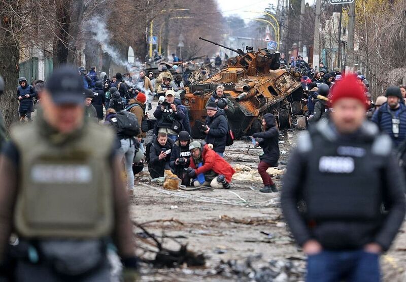 A group of journalists photographs a cat in Bucha, Ukraine. April 3, 2022 